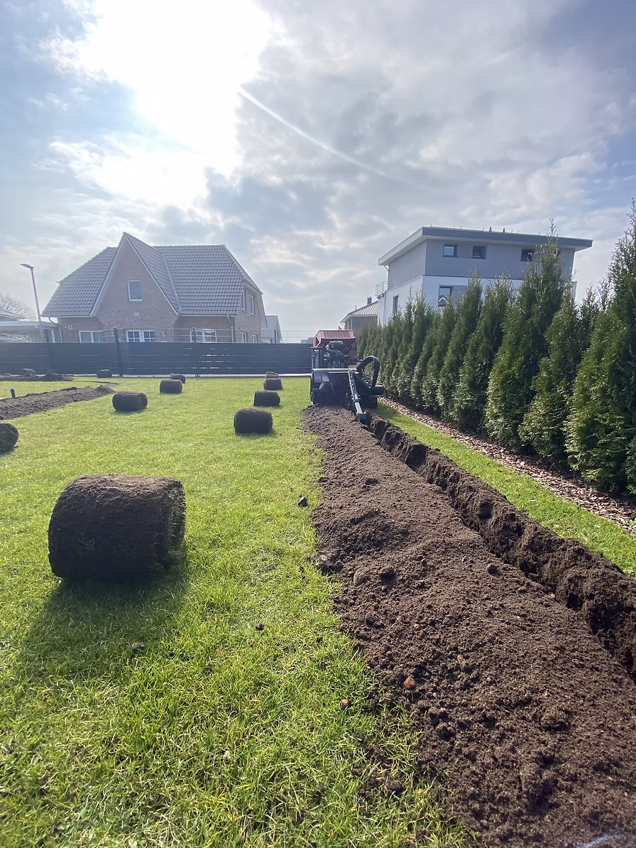 Rollrasen verlegen mit frisch gezogenem Leitungsgraben